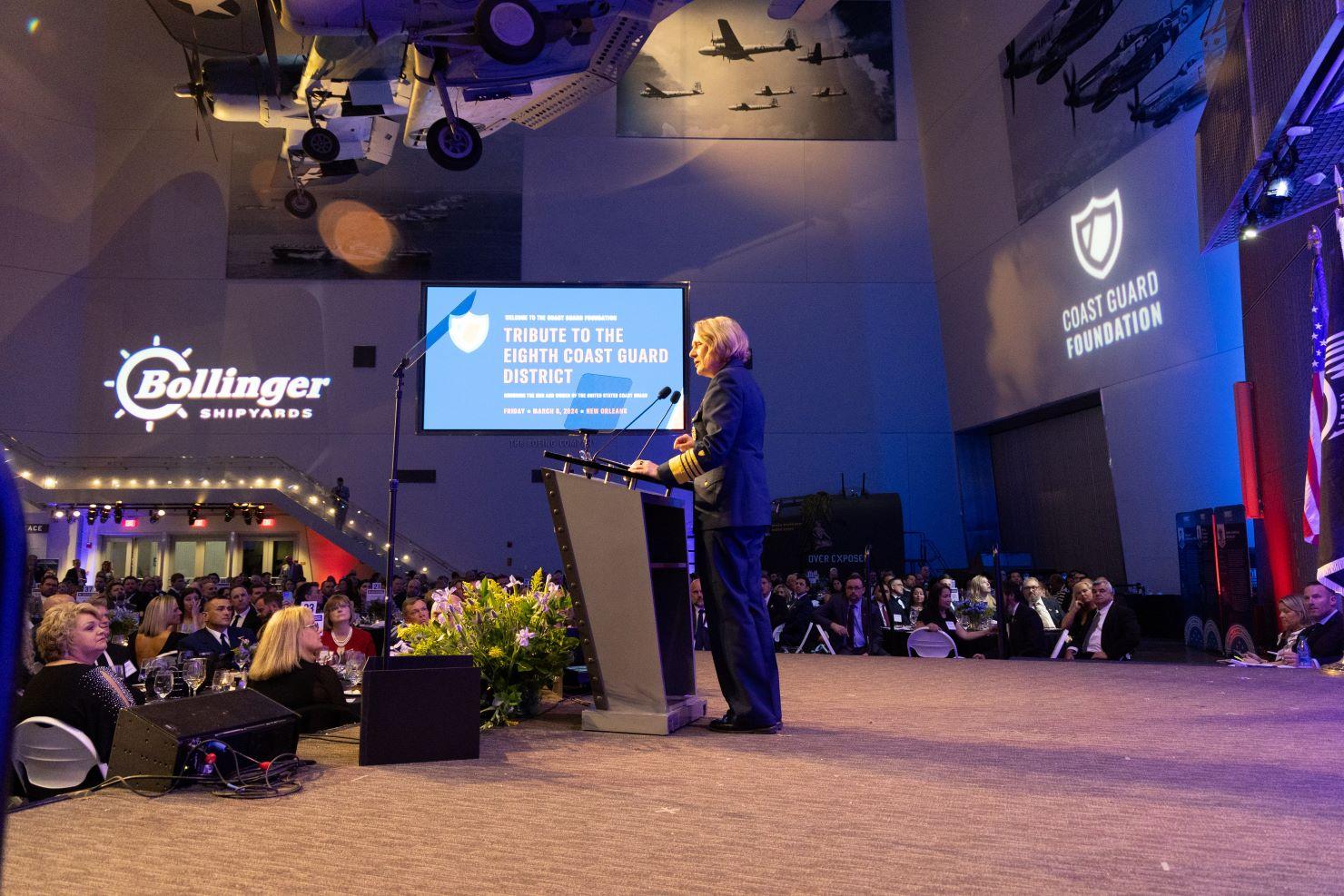 The Coast Guard Commandant standing at a podium on stage.