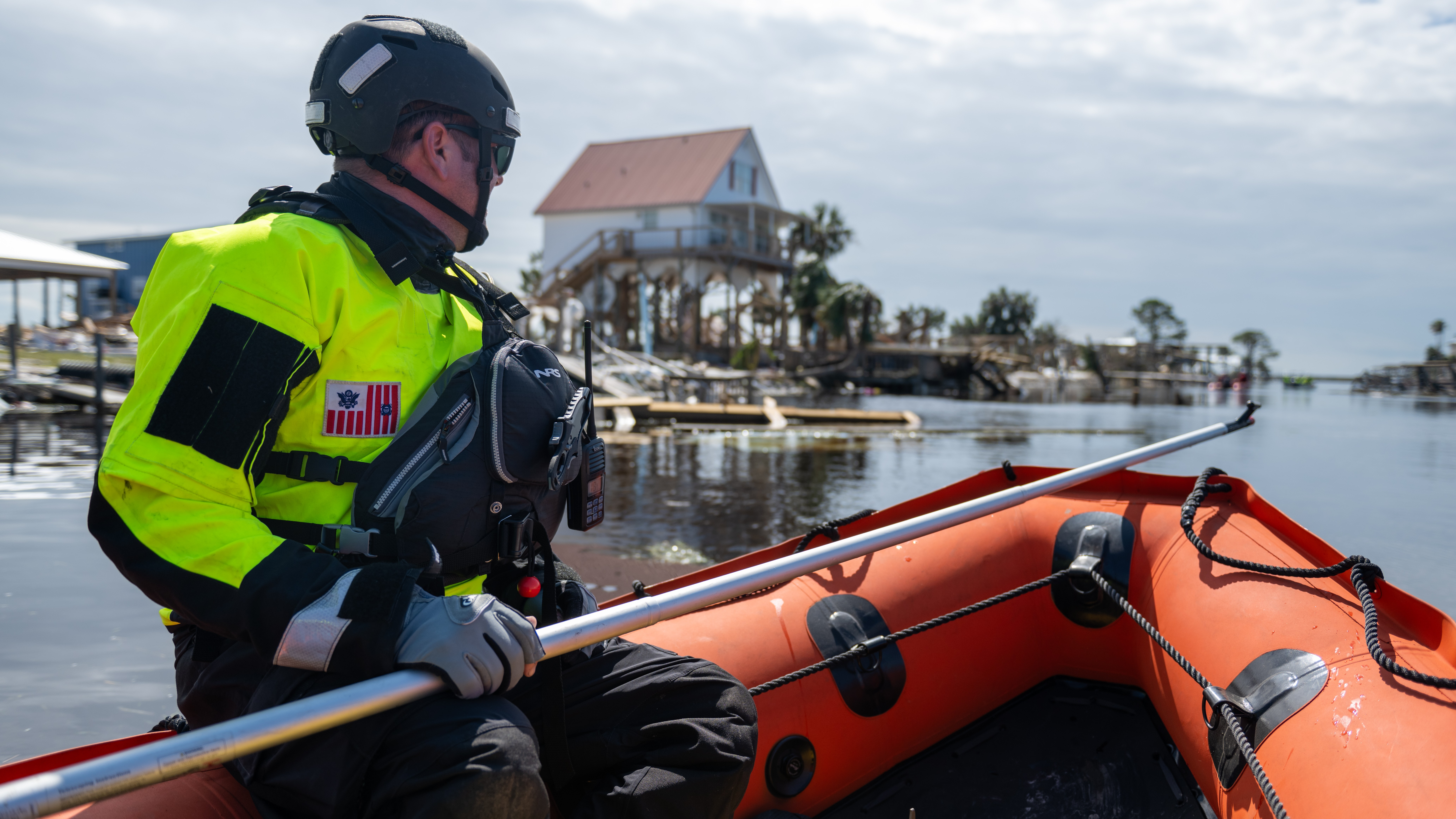 A Coast Guard member in an inflatable boat.