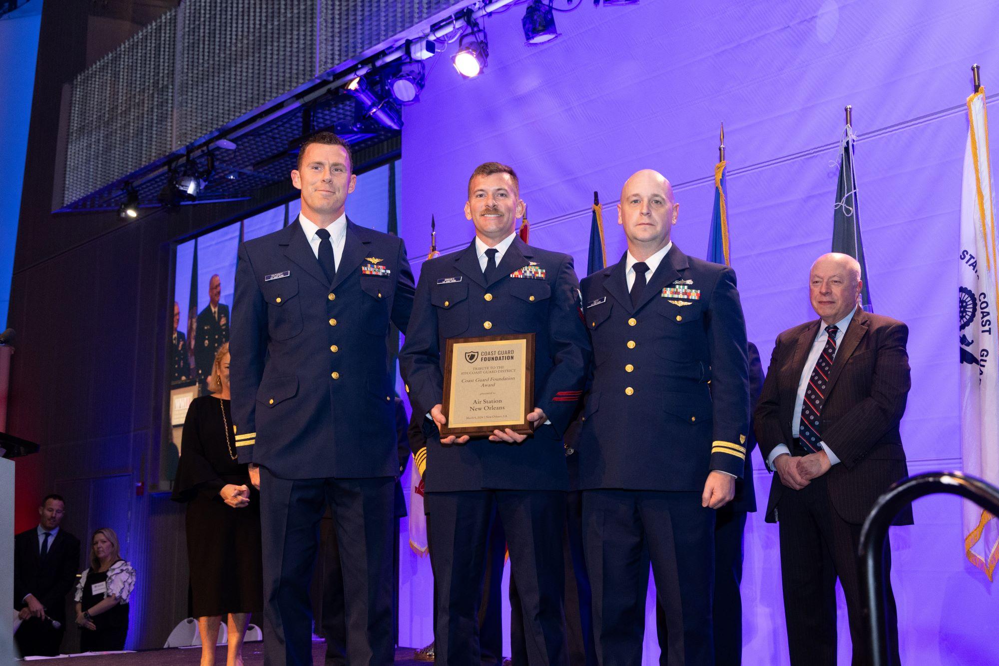 3 Coast Guard members accept an award