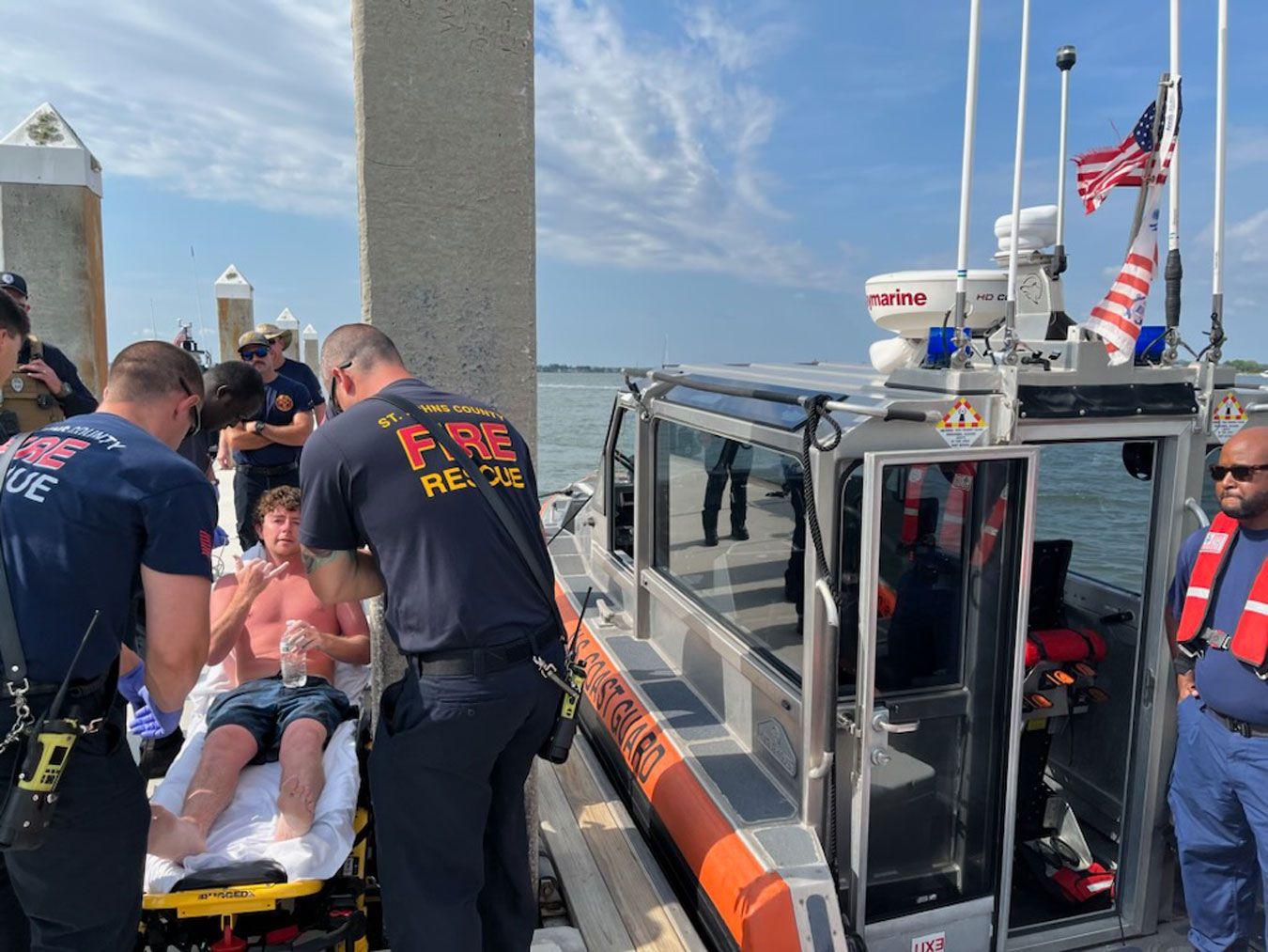 EMS crews and patient in front of a boat.