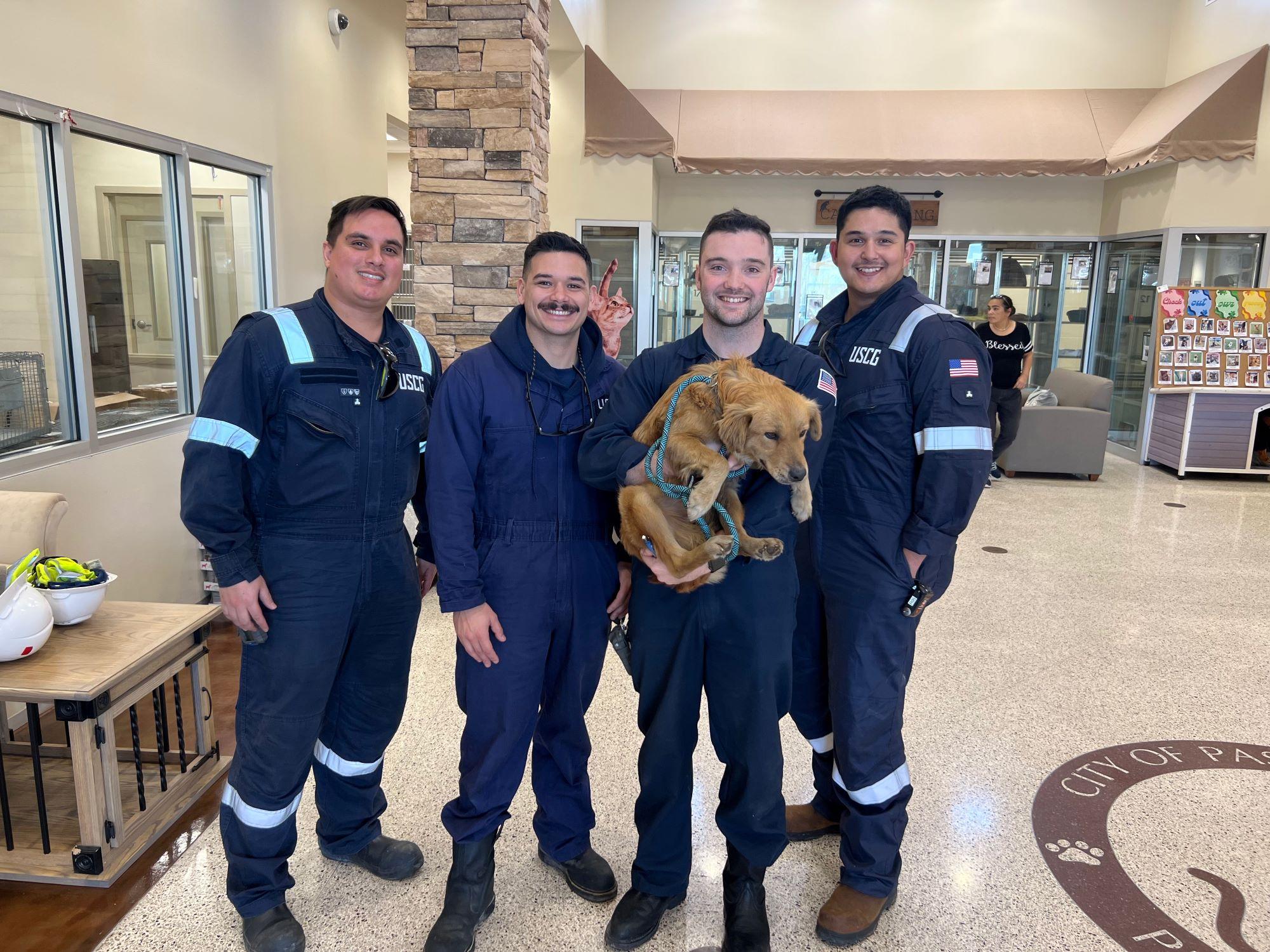 Four men pose with a yellow dog.