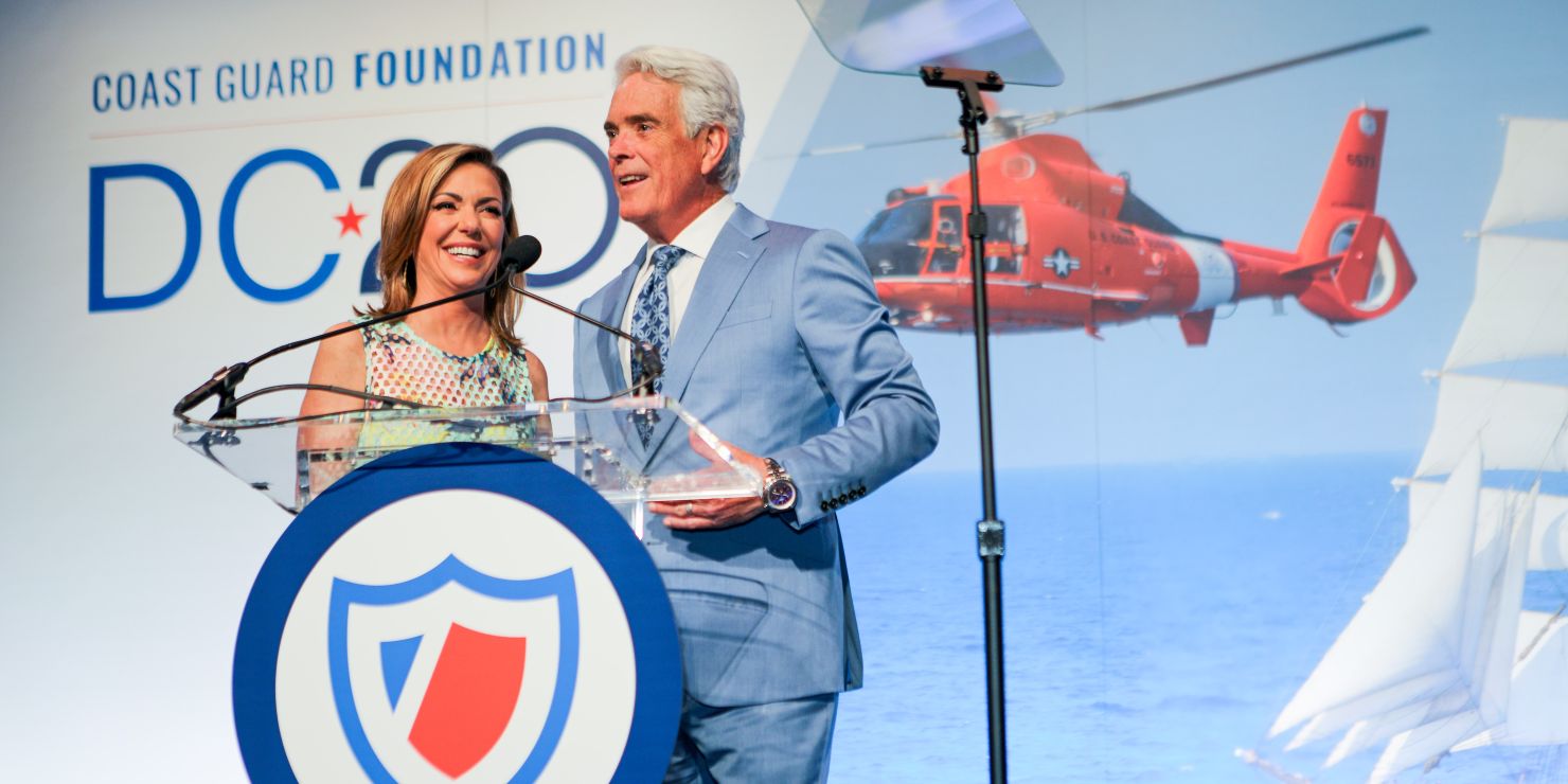 A man and a women stand on stage.