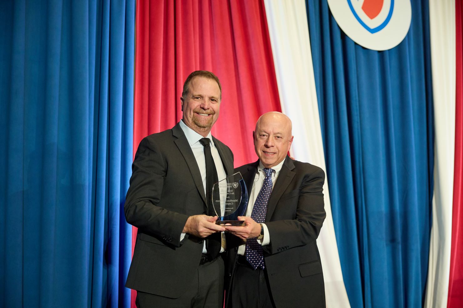 Two men standing with a trophy