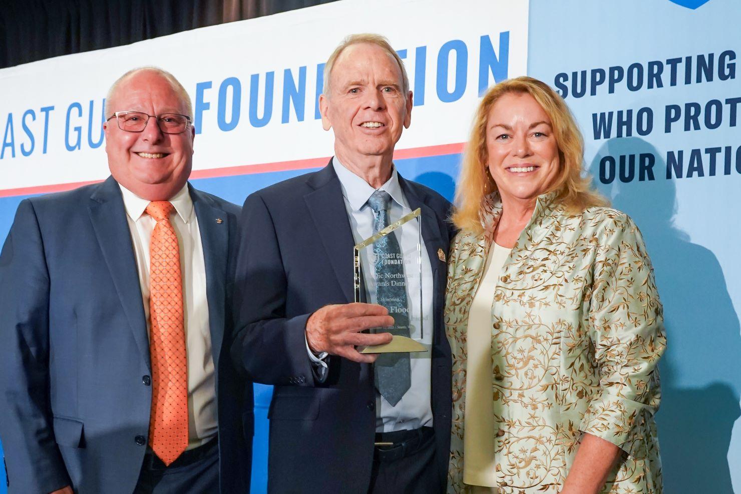 Keith Taylor, Mike Flood and Susan Ludwig smiling on stage.