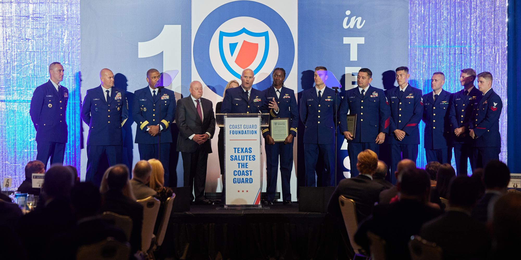 Lieutenant Commander Matthew Krueger accepts the Coast Guard Foundation award on behalf of Coast Guard Air Stations Corpus Christi and Houston at the 2025 Coast Guard Foundation Texas Salutes the Coast Guard event held in Houston on November 18, 2025.