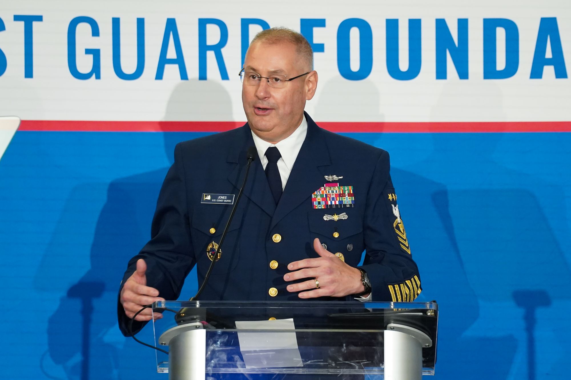 A Coast Guard member speaking at a podium