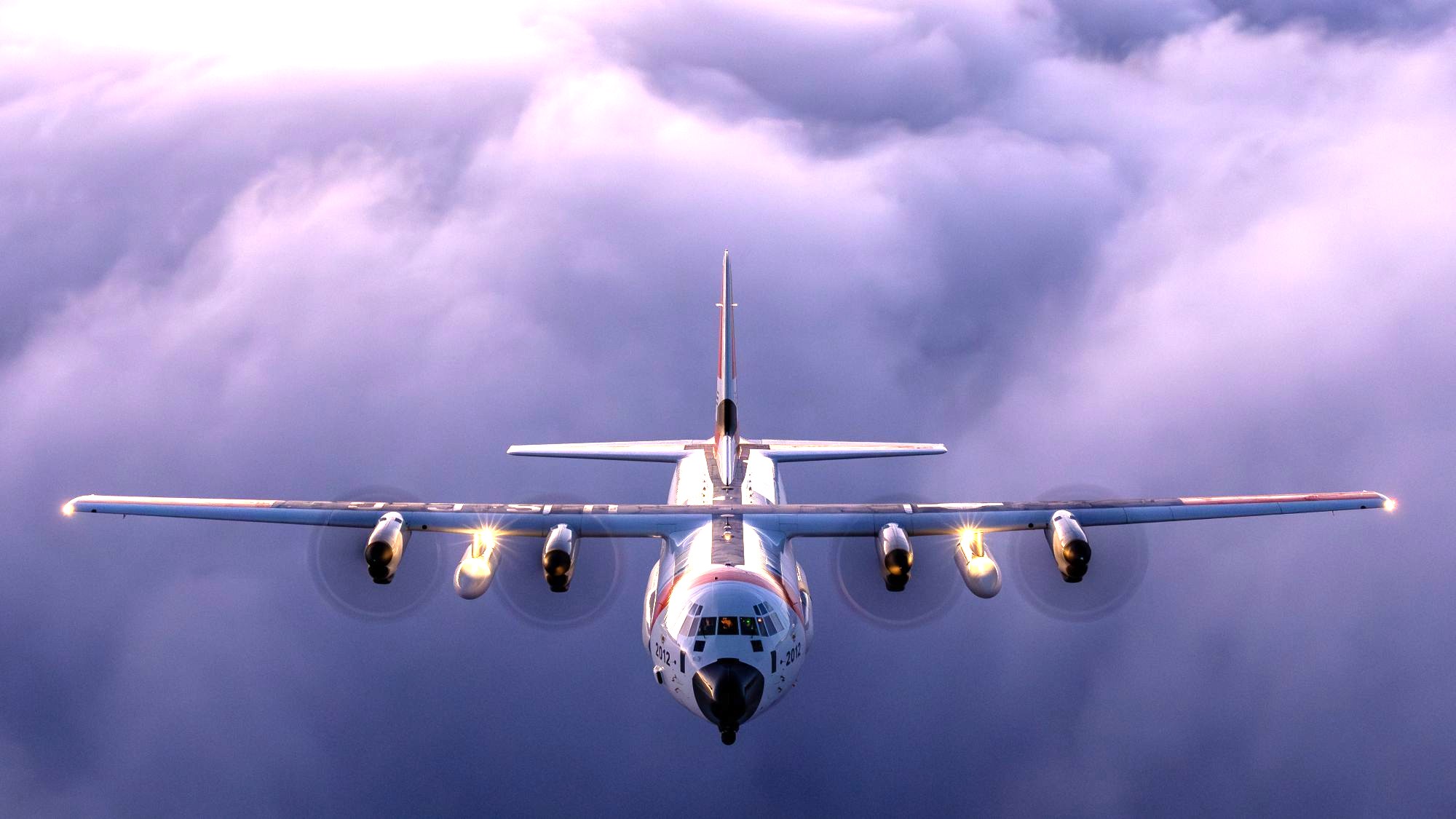 A U.S. Coast Guard HC-130 Hercules airplane flies above the clouds.