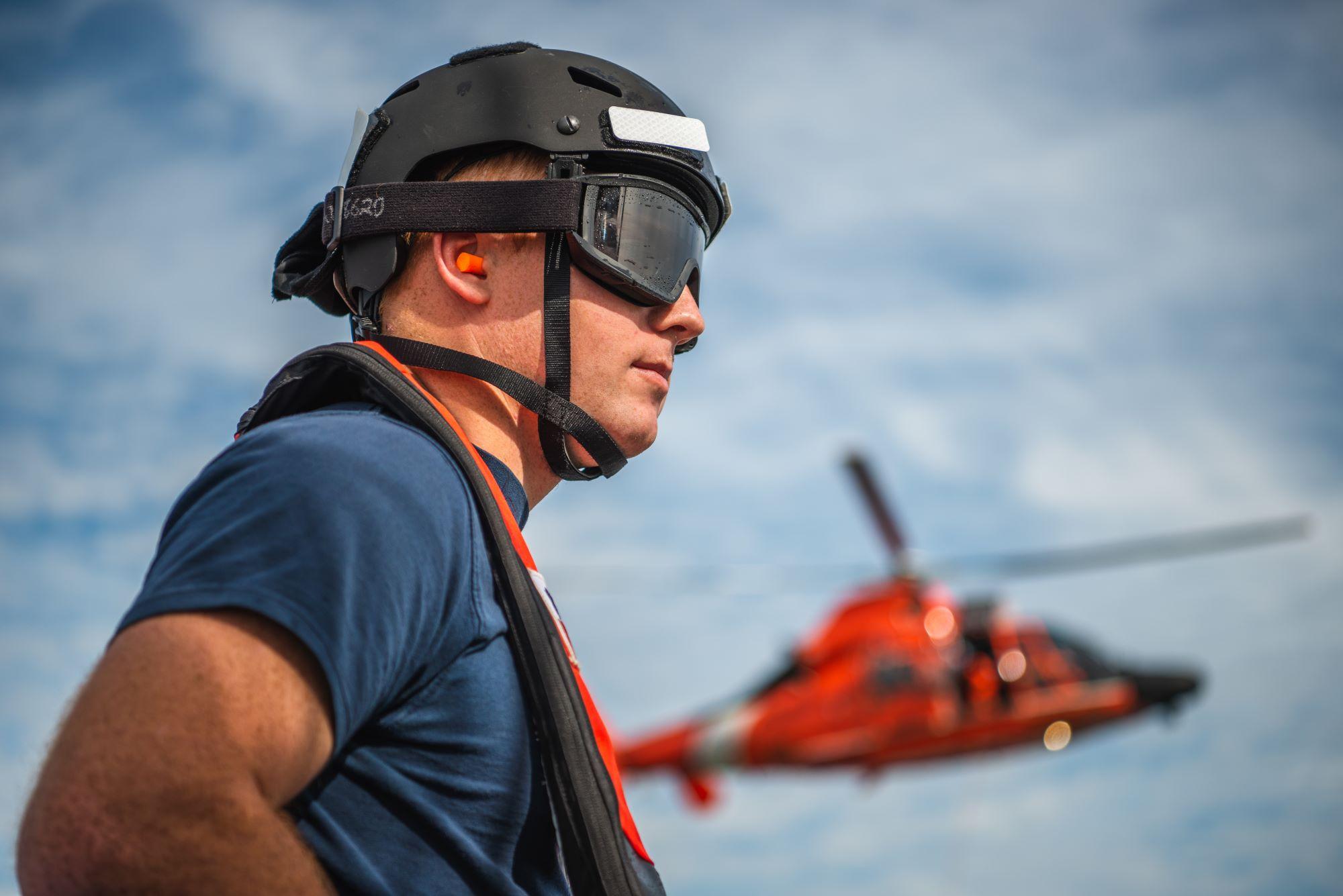 Coast Guard member with helicopter in the background