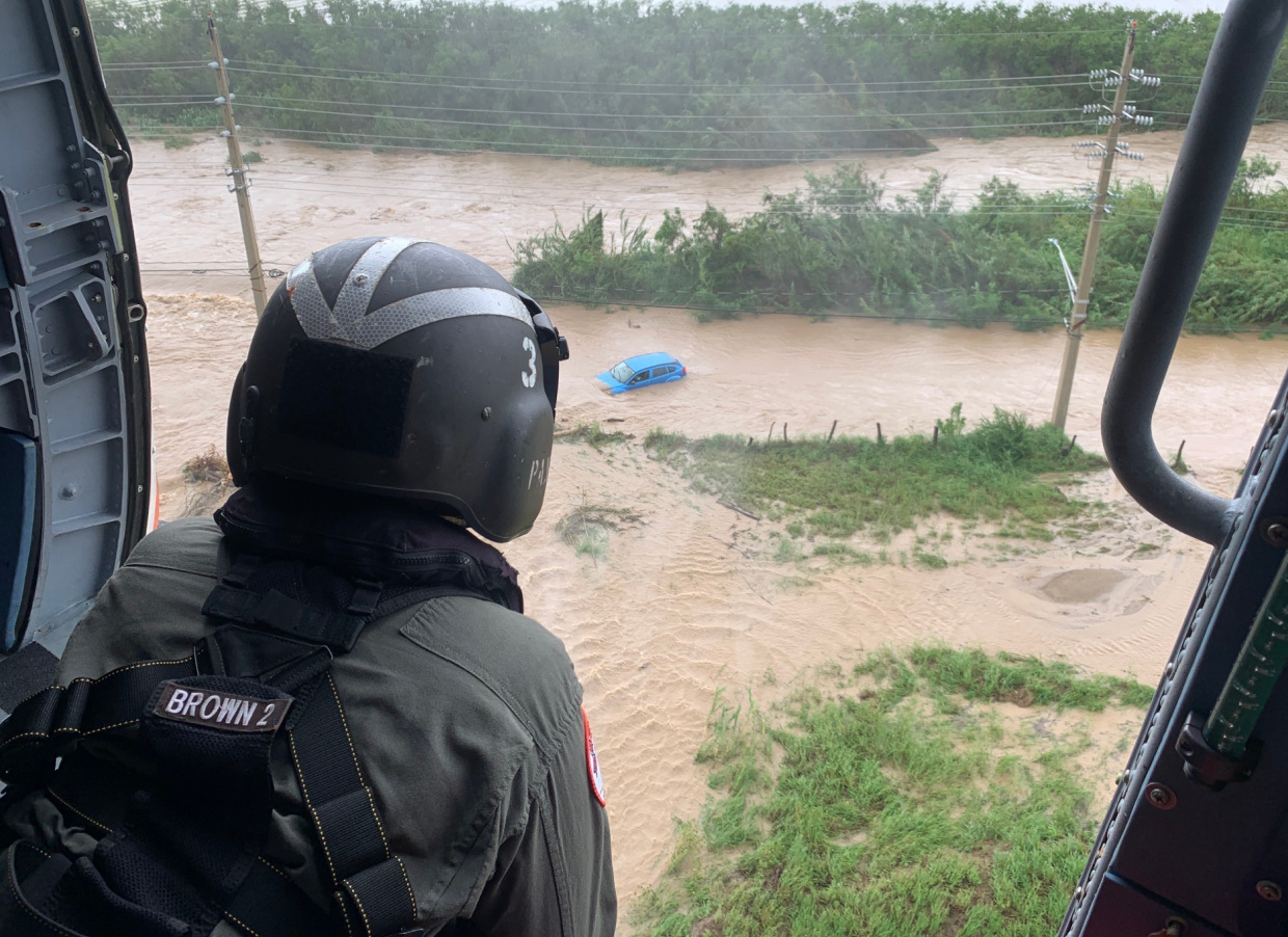A HELICOPTER CREWMEMBER FROM AIR STATION BORINQUEN LOOKS FOR SURVIVORS ALONG THE SOUTHERN COAST OF PUERTO RICO FOLLOWING HURRICANE FIONA IN MID-SEPTEMBER. USCG PHOTO BY CAPT ROBERT PIRONE